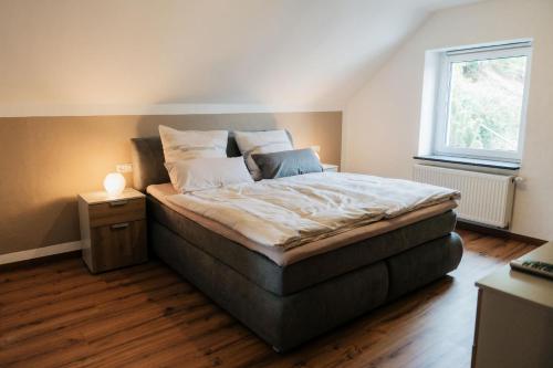 a large bed in a room with a window at Ferienhaus Maarwinkel in Gillenfeld