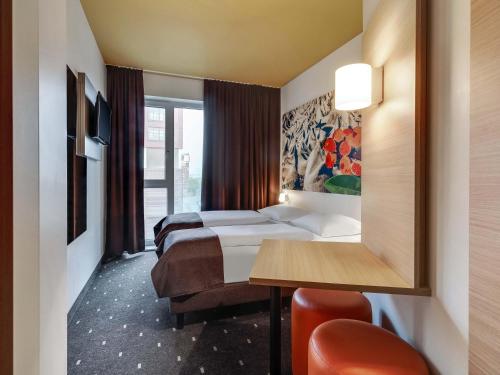 a hotel room with two beds and a mirror at B&B Hotel Bremen-Überseestadt in Bremen