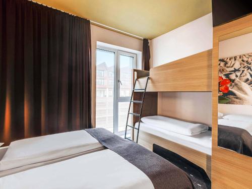 a bedroom with two bunk beds and a window at B&B Hotel Bremen-Überseestadt in Bremen