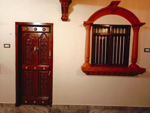 a wooden cabinet and a window on a wall at Chola Heritage Resort in Kāraikkudi