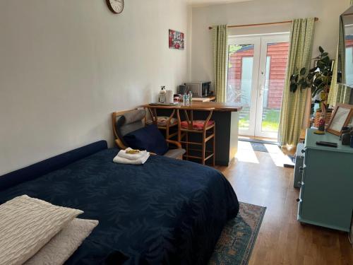 a bedroom with a bed and a desk and a table at Cherry Hill Studio in Caversham