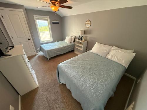 a bedroom with two beds and a ceiling fan at Wine Down in Hammondsport