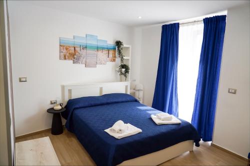 a bedroom with a blue bed with two towels on it at etna sea live catania center home in Catania