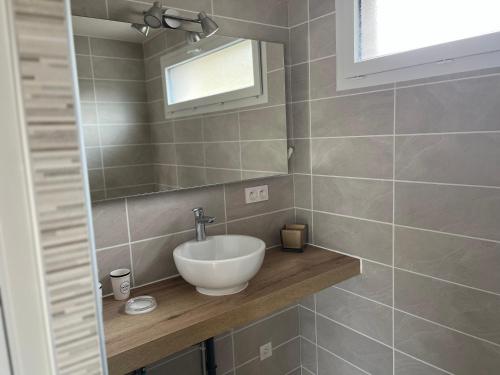 a bathroom with a sink and a mirror at Charmant logement avec terrasse et parking sécurisé in Arpajon-sur-Cère