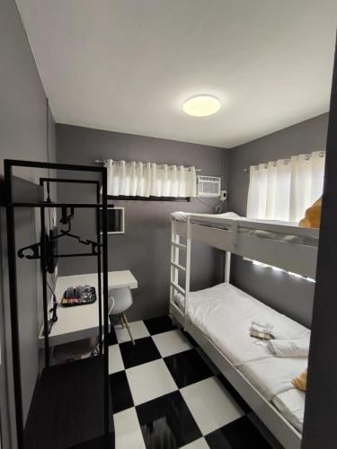 two bunk beds in a room with a checkered floor at AMS Hostel Butuan City in Butuan