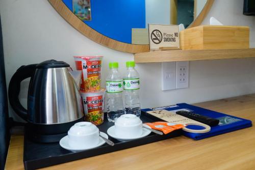 a counter top with a coffee maker and bottles of water at Tina's House & Spa - Sunset Town Phu Quoc in Phu Quoc