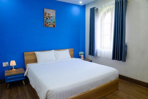 a blue bedroom with a bed and a blue wall at Tina's House & Spa - Sunset Town Phu Quoc in Phu Quoc