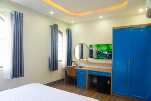 a bedroom with a blue cabinet and a desk with a mirror at Tina's House & Spa - Sunset Town Phu Quoc in Phu Quoc