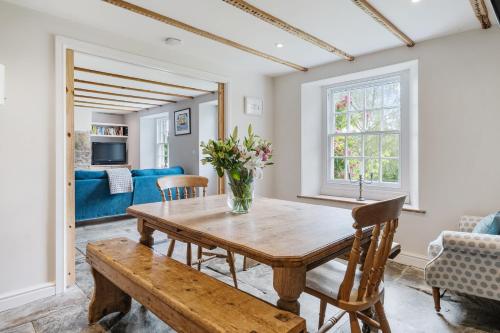 a dining room with a wooden table and chairs at Treovis Farm in Callington