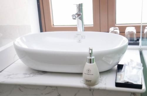 a white sink sitting on a counter in a bathroom at Tina's House & Spa - Sunset Town Phu Quoc in Phu Quoc
