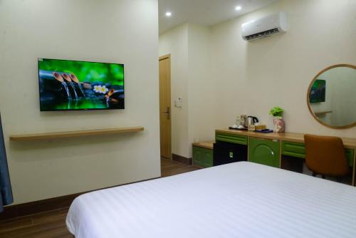 a hotel room with a bed and a tv on the wall at Tina's House & Spa - Sunset Town Phu Quoc in Phu Quoc