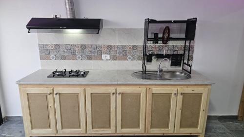 a kitchen counter with a sink and a stove at Dream View Luxe in Rafrāf