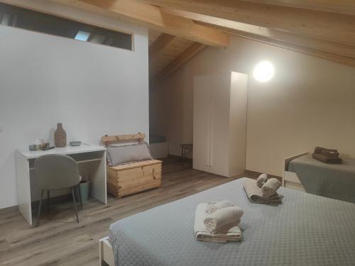 a room with two beds and a table and a desk at Casa Cuor di Castagno in Roncegno