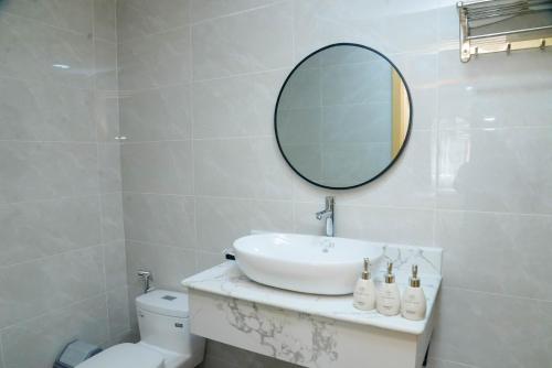 a bathroom with a sink and a mirror on the wall at Tina's House & Spa - Sunset Town Phu Quoc in Phu Quoc