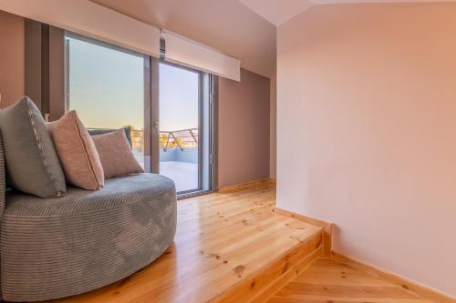 a living room with a couch and a large window at Azure Sofia - Maisonette in Lampi