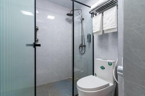 a bathroom with a toilet and a glass shower at Casa Inikas -Luxurious 1 bedroom Marina Bay in Nairobi