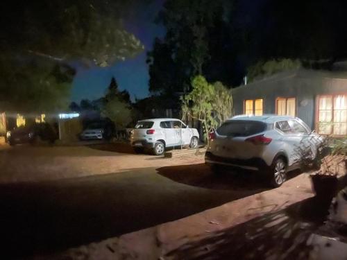 two cars parked in front of a house at night at Cabañas La Magia de Isla Negra in Isla Negra
