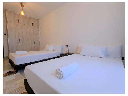 two beds with white sheets in a room at Bahari elegance in Mombasa