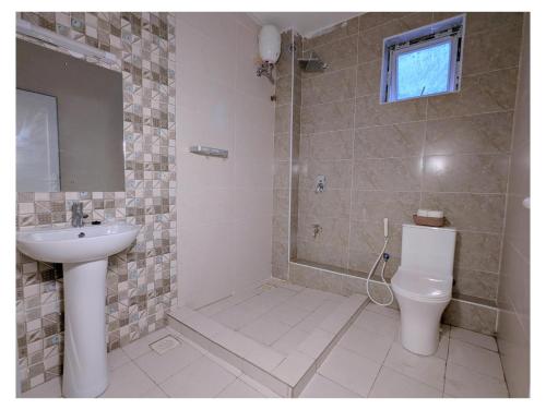 a bathroom with a toilet and a sink and a shower at Bahari elegance in Mombasa
