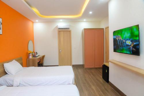 a hotel room with two beds and a flat screen tv at Tina's House & Spa - Sunset Town Phu Quoc in Phu Quoc