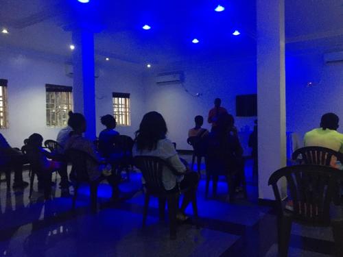 a group of people sitting in a room with blue lights at Amoni Apartments in Port Harcourt