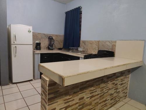 a kitchen with a refrigerator and a counter top at casa bugambilias in Loreto