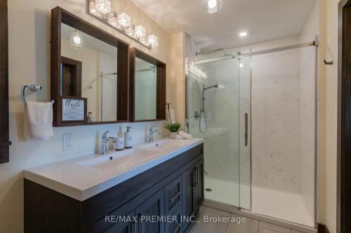 a bathroom with a sink and a glass shower at Four Season Waterfront Muskoka Retreat in Bracebridge
