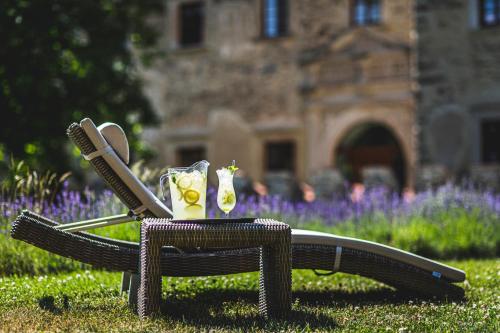 a wicker chair with two cocktails on it in the grass at Uroczysko Siedmiu Stawów Spa by L'Occitane in Gola Dzierżoniowska