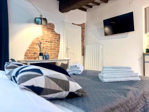 a bedroom with a bed with a tv on the wall at Sogni sul Lago - Passignano sul Trasimeno in Passignano sul Trasimeno
