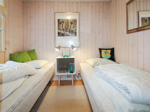a bedroom with two beds and a tv in it at Holiday Home Arton - 300m from the sea by Interhome in Ebberup
