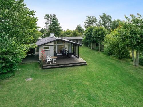 a small house with a deck and a yard at Holiday Home Juditha - 400m from the sea by Interhome in Middelfart