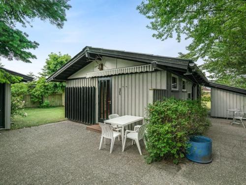 a table and chairs in front of a shed at Holiday Home Juditha - 400m from the sea by Interhome in Middelfart