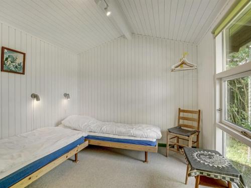 a bedroom with a bed and a chair and a window at Holiday Home Juditha - 400m from the sea by Interhome in Middelfart