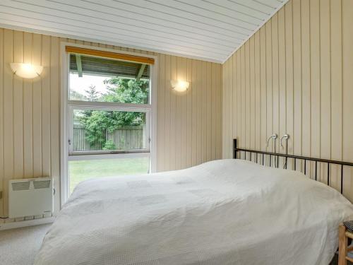 a bedroom with a white bed and a window at Holiday Home Juditha - 400m from the sea by Interhome in Middelfart