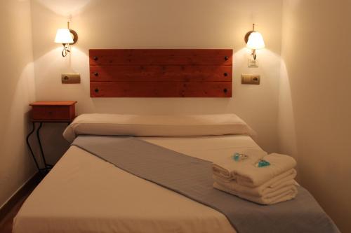 a room with three beds with towels on the bed at Hostal Amantes De Teruel in Teruel