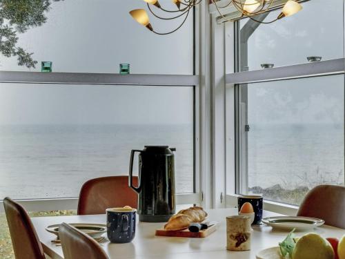 a table with a coffee maker on a table in front of a window at Holiday Home Selja - 15m from the sea by Interhome in Oure