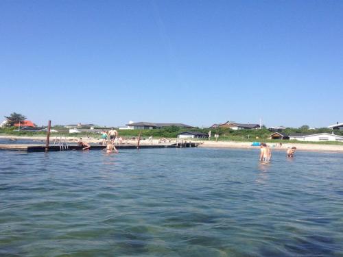 a group of people in the water at a beach at Holiday Home Dunya - 400m from the sea by Interhome in Assens