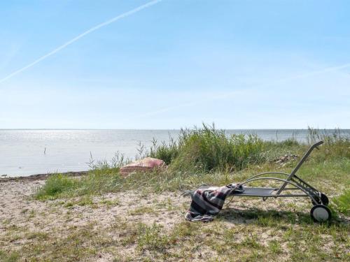 a small cart sitting on the beach next to the water at Holiday Home Selja - 15m from the sea by Interhome in Oure