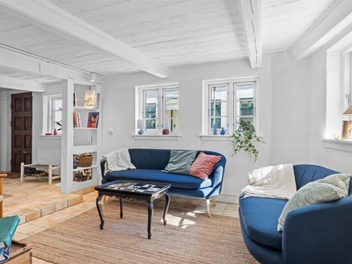 a living room with a blue couch and a table at Apartment Gaby - 250m from the sea by Interhome in Assens