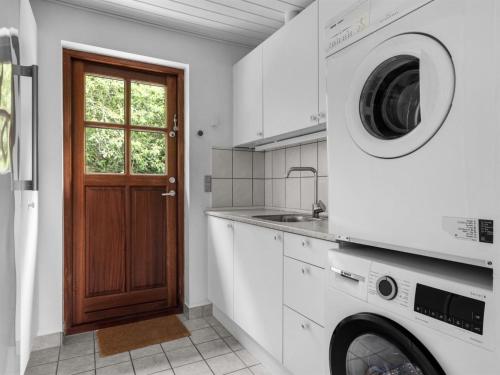 a kitchen with a washing machine and a sink at Holiday Home Jorith - 550m from the sea by Interhome in Tranekær