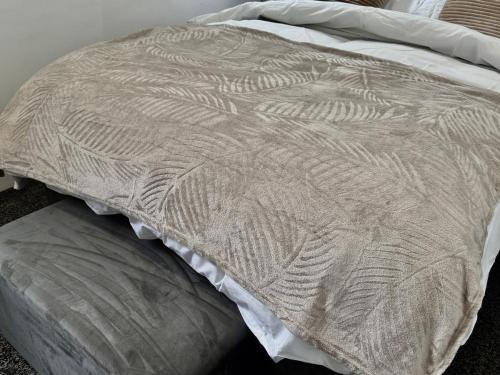 a close up of a bed with a white comforter at Pendle view- luxurious Studio in Brierfield
