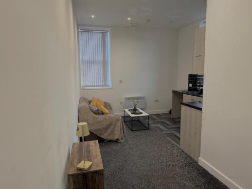 a living room with a couch and a table at Pendle view- luxurious Studio in Brierfield