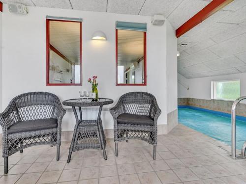 a dining room with a table and chairs and a swimming pool at Holiday Home Emly - 1-1km from the sea by Interhome in Humble