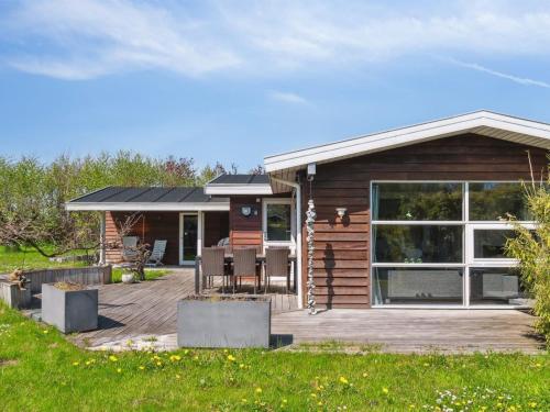 a log cabin with a deck and a patio at Holiday Home Bjarke - 200m from the sea by Interhome in Frørup