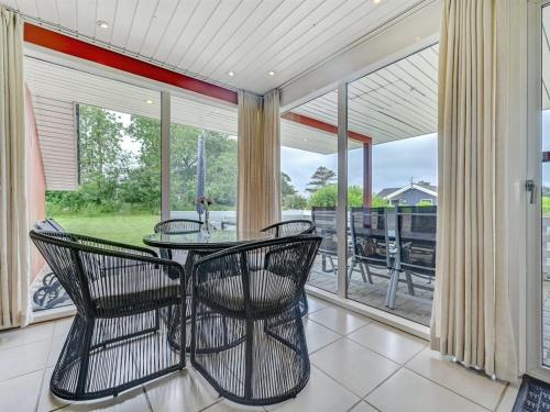 a dining room with a table and chairs on a balcony at Holiday Home Emly - 1-1km from the sea by Interhome in Humble