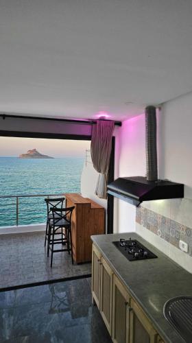 a kitchen with a stove and a view of the ocean at Dream View Luxe in Rafrāf