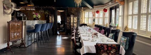 a dining room with a long table with plates and cups at Brockley Hall Hotel in Saltburn-by-the-Sea