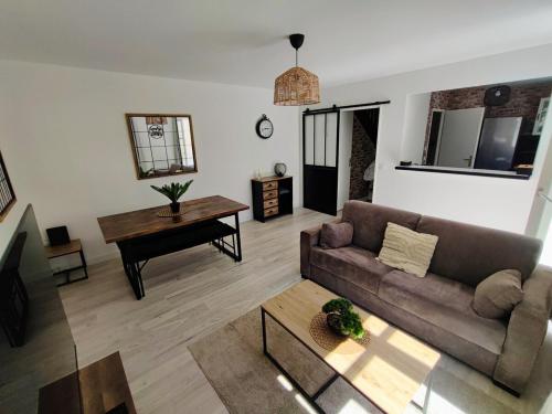 ein Wohnzimmer mit Sofa und Tisch in der Unterkunft House 64 m2 - 2 bedrooms near Disneyland Paris in Bailly-Romainvilliers