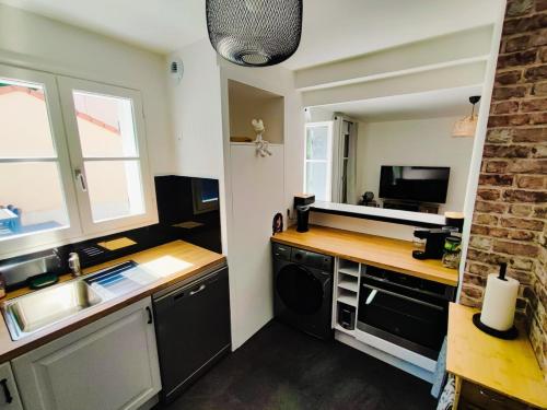 eine Küche mit Spüle und Herd oberen Backofen in der Unterkunft House 64 m2 - 2 bedrooms near Disneyland Paris in Bailly-Romainvilliers