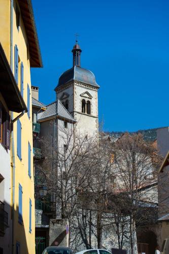a tall building with a clock tower on top of it at Maison à Tour Briançon in Briançon